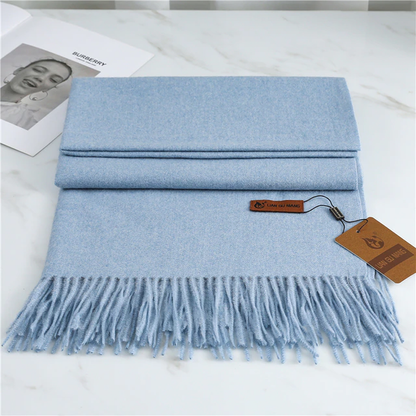 Light blue scarf with tassels on a white surface