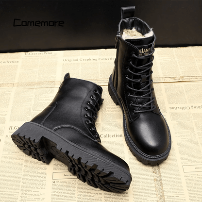Black leather boots on a newspaper background with 'Camemore' branding.