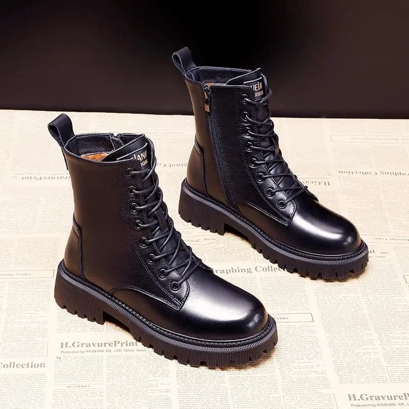 Pair of black leather boots on a textured surface