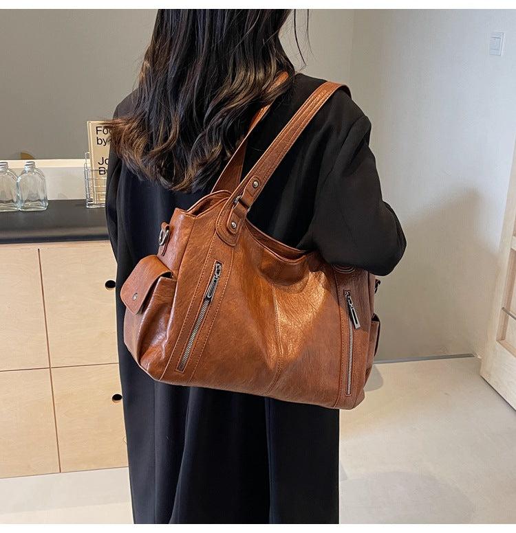 Person wearing a brown leather backpack indoors