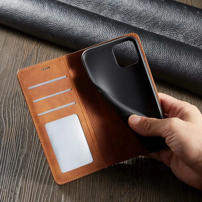 Brown leather phone wallet with a phone inside, held by a hand on a wooden surface.