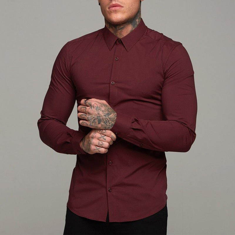 Man wearing a burgundy shirt against a gray background