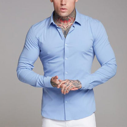 Man wearing a light blue dress shirt against a gray background