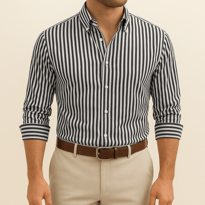 Man wearing a black and white striped shirt with beige pants on a beige background