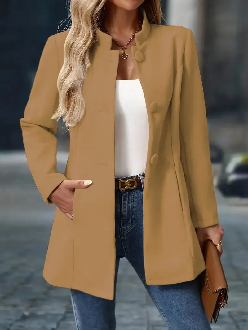 Woman wearing a beige coat with a blurred street background
