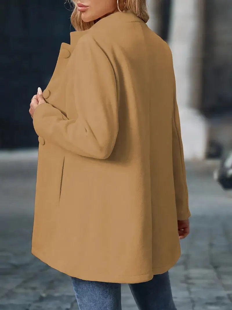 Person wearing a brown coat on a blurred street background