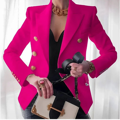 Person wearing a bright pink blazer with gold buttons, holding a black handbag.