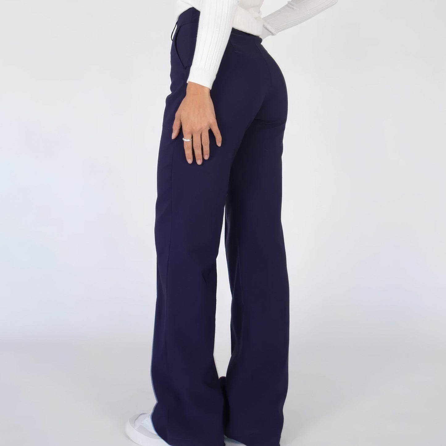 Navy blue pants worn by a person on a white background