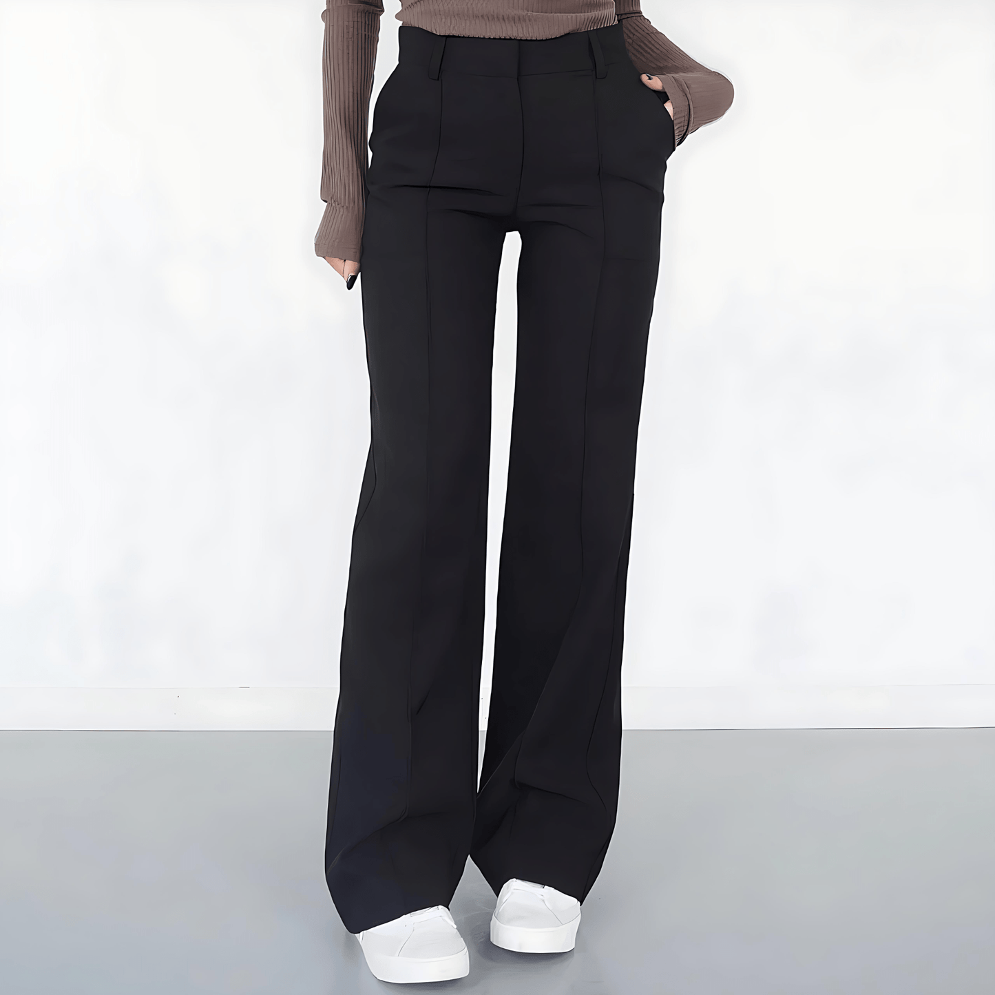 Person wearing black wide-leg pants on a white background