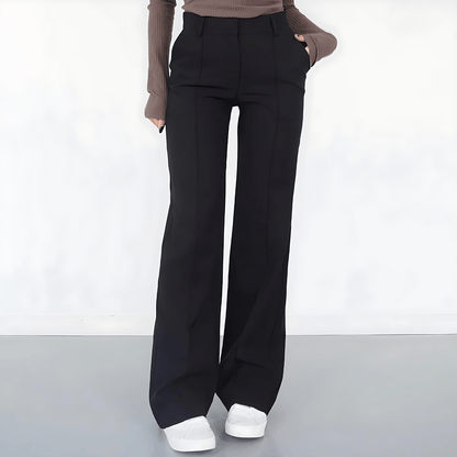 Person wearing black wide-leg pants on a white background