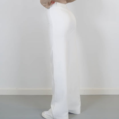 Person wearing white pants against a plain white background