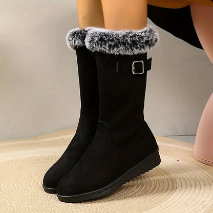 Black knee-high boots with fur trim on a neutral background