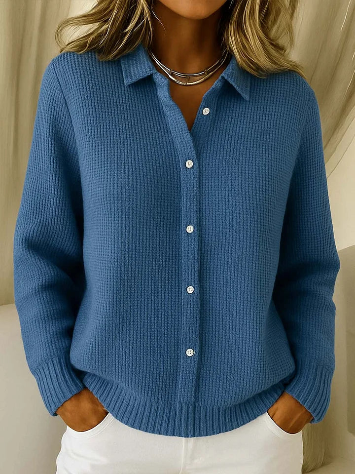 Blue knitted cardigan worn by a person against a neutral background