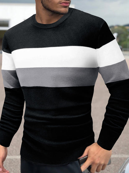 Person wearing a black, gray, and white striped sweater outdoors.