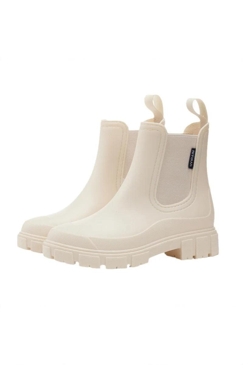Pair of cream-colored rain boots on a white background