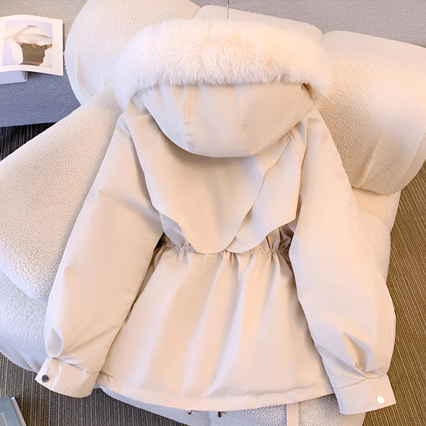 Beige hooded jacket with fur trim on a chair