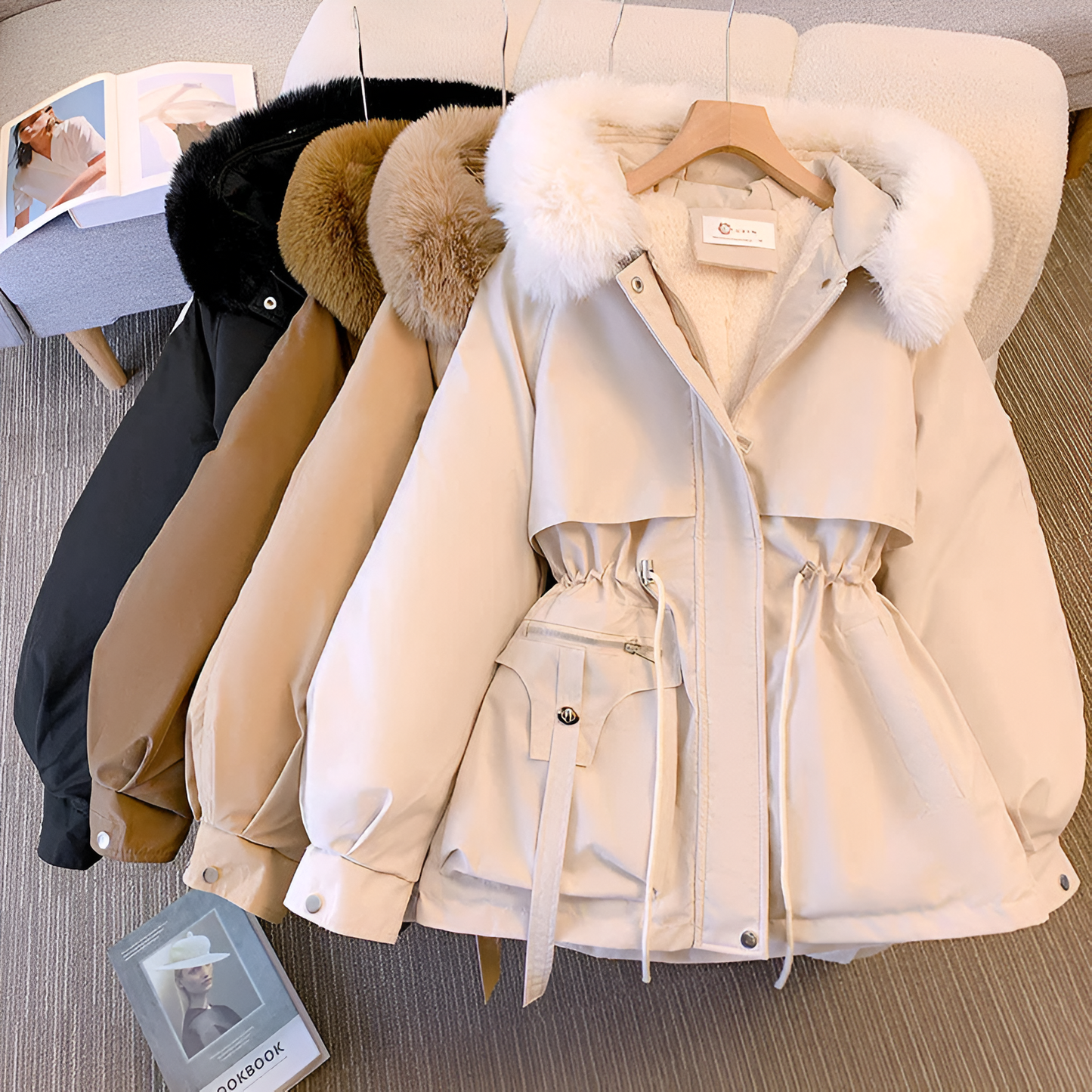 Beige parka with fur trim on a hanger against a neutral background