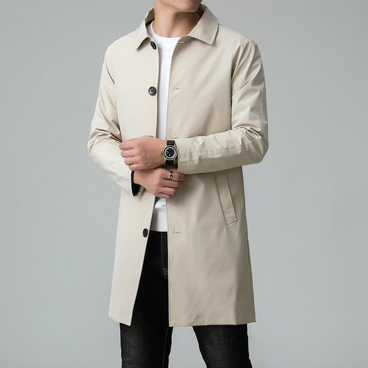 Man wearing a beige trench coat on a gray background