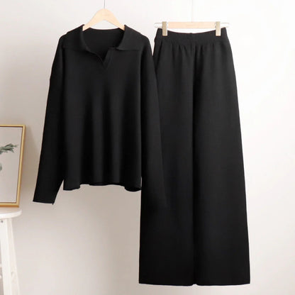 Black long-sleeve top and black skirt on hangers against a white background