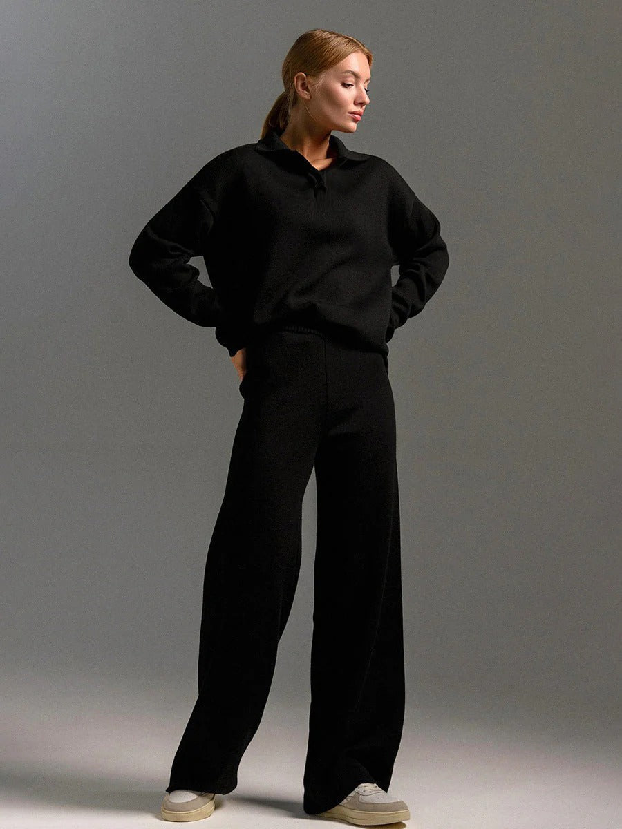 Person wearing a black outfit against a gray background