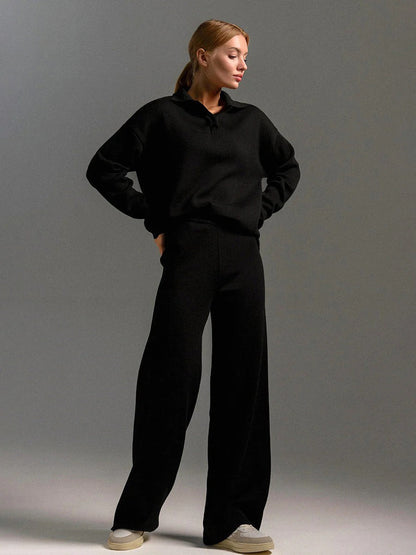 Person wearing a black outfit against a gray background