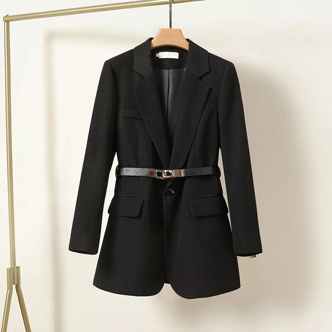 Black blazer with a belt on a hanger against a neutral background