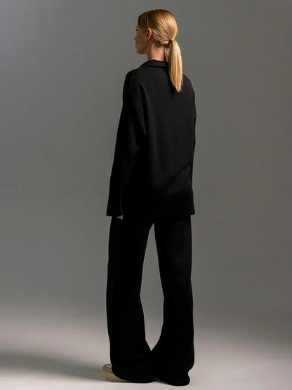 Person wearing a black outfit against a gray background