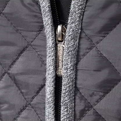 Close-up of a quilted jacket zipper with a brand logo.