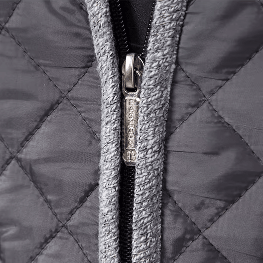 Close-up of a quilted jacket zipper with a brand logo.