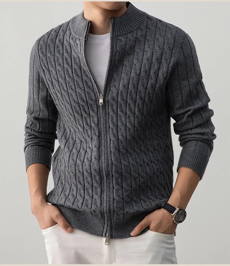 Person wearing a gray cable knit sweater with a zipper on a light gray background