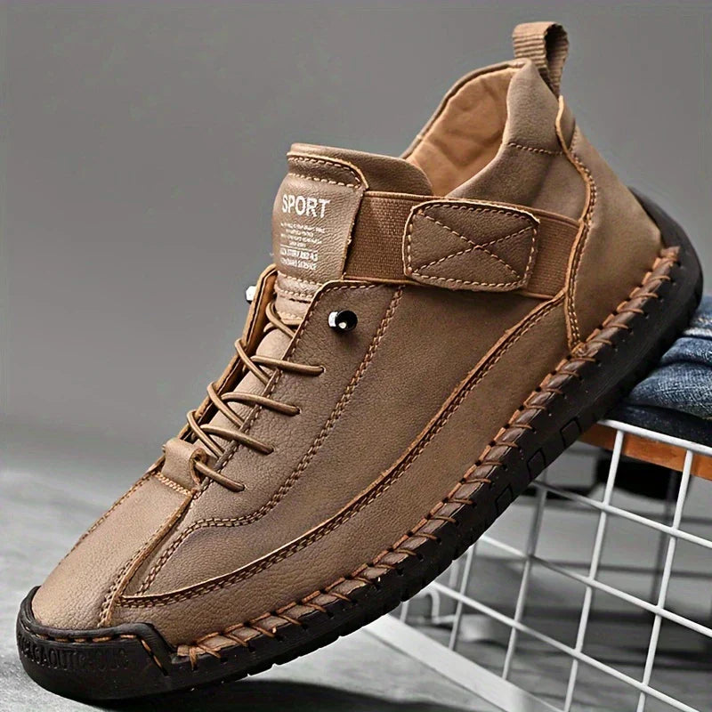 Brown leather shoe with black sole on a gray background