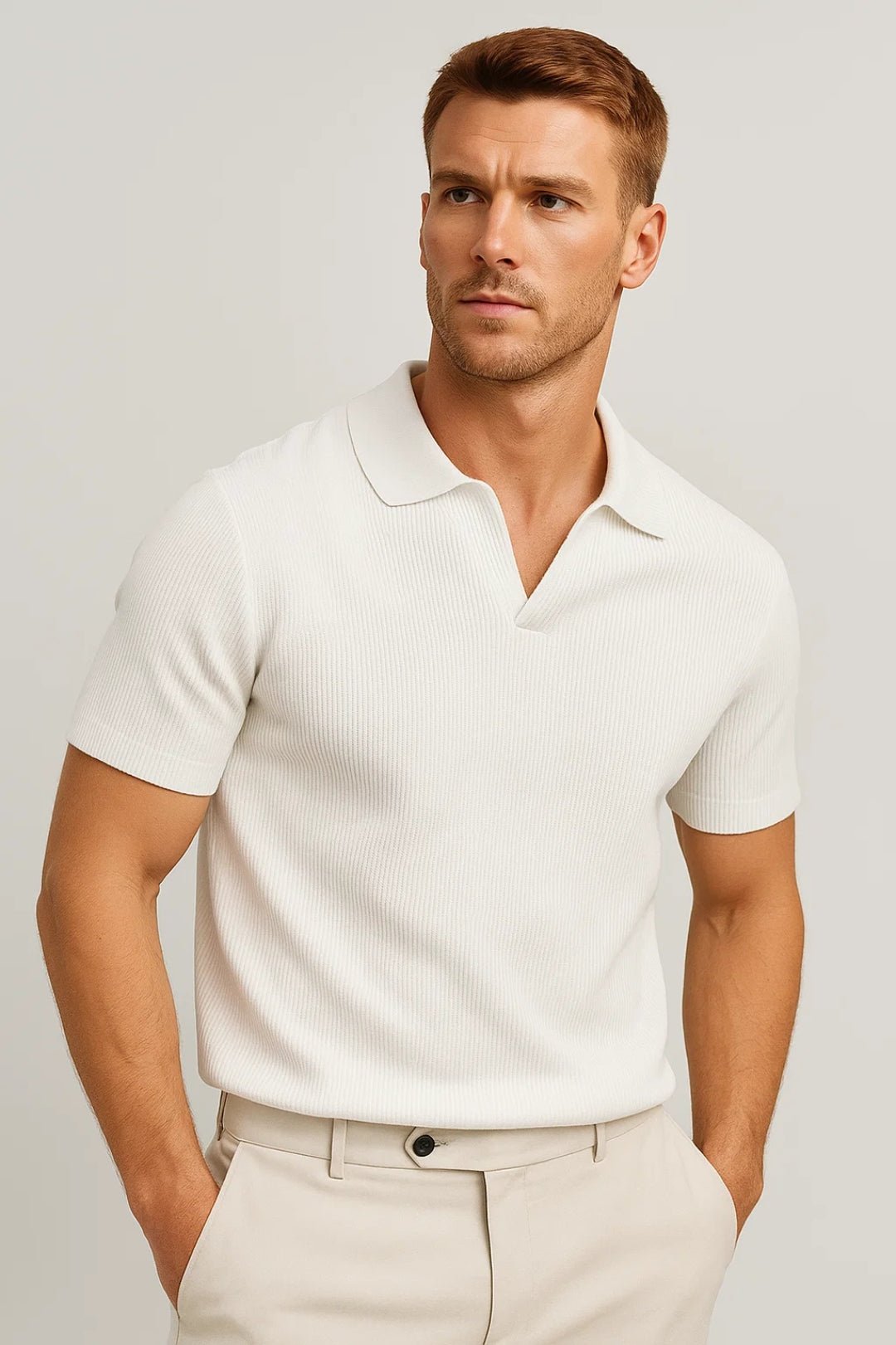 Man wearing a white polo shirt and beige pants against a light gray background