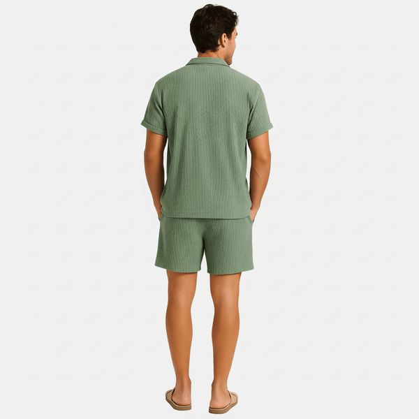 Man wearing a green textured shirt and shorts set on a white background