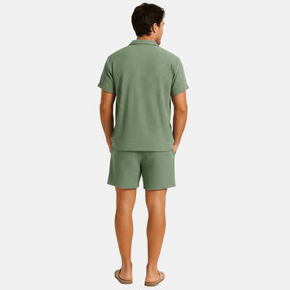 Man wearing a green textured shirt and shorts set on a white background