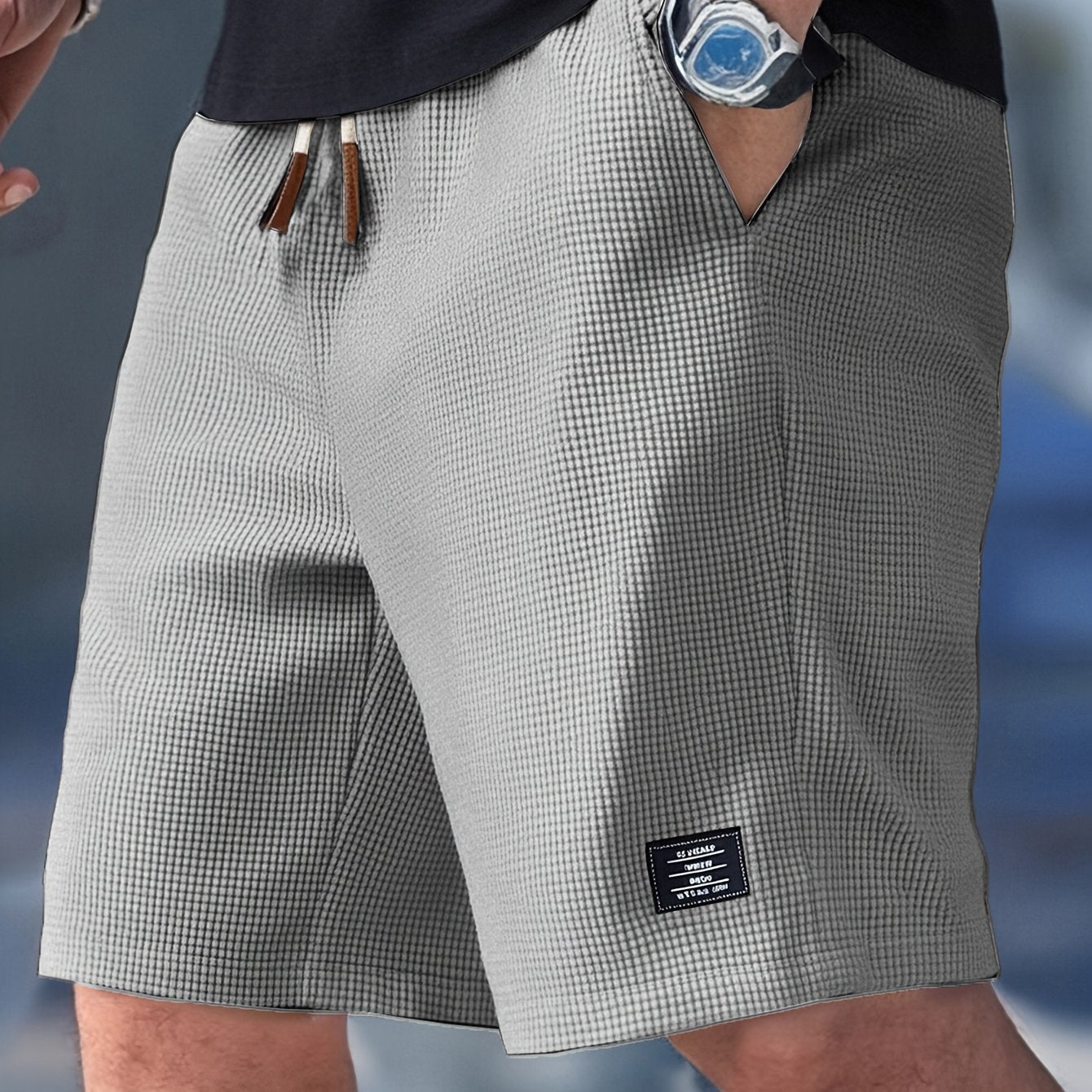 Gray checkered shorts with a brand label on a blurred background