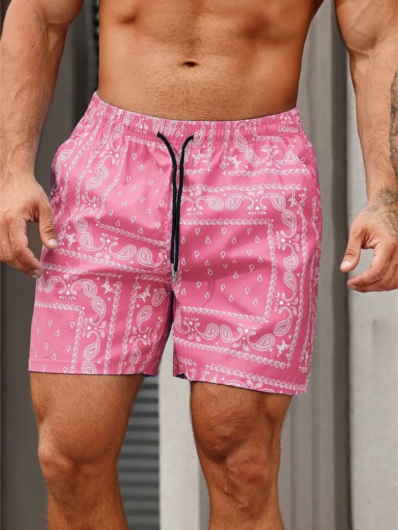 Pink swim shorts with white paisley pattern worn by a person.