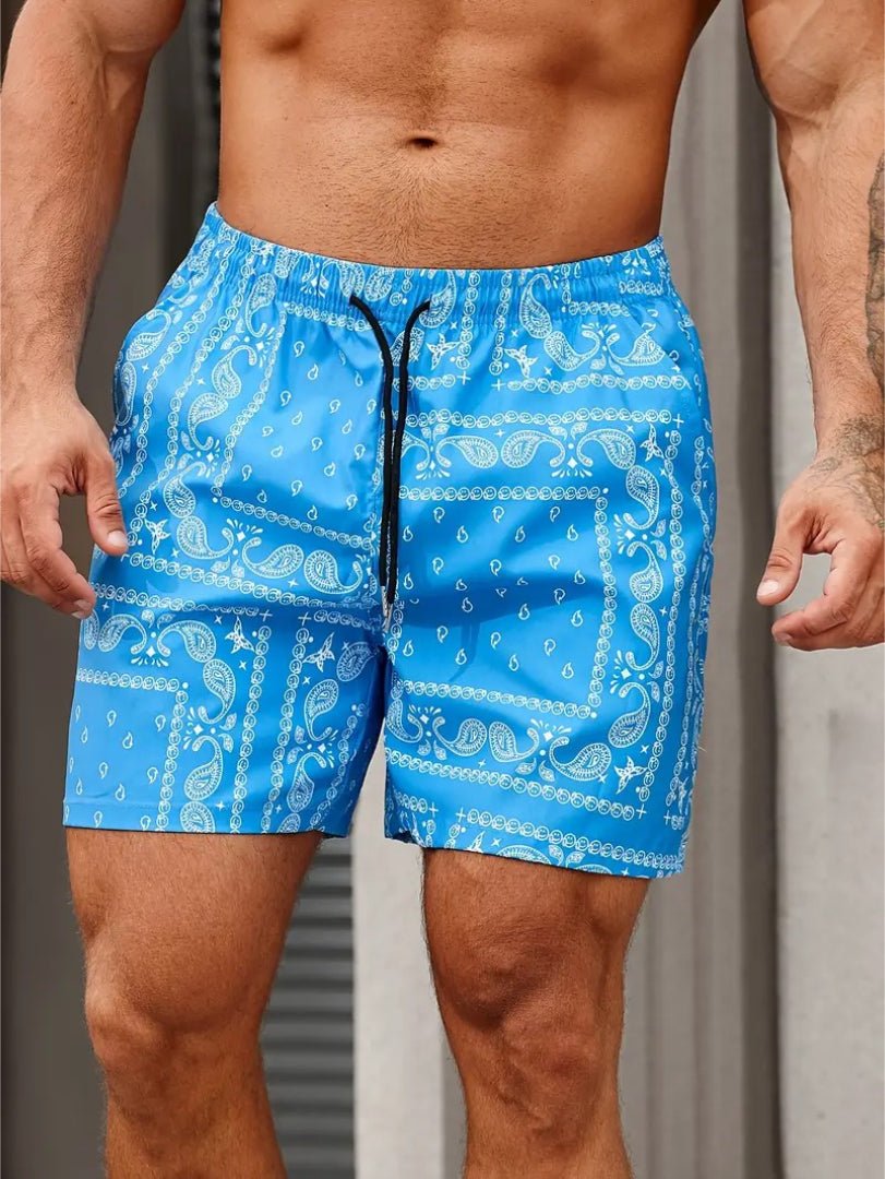 Blue patterned swim shorts worn by a person against a neutral background