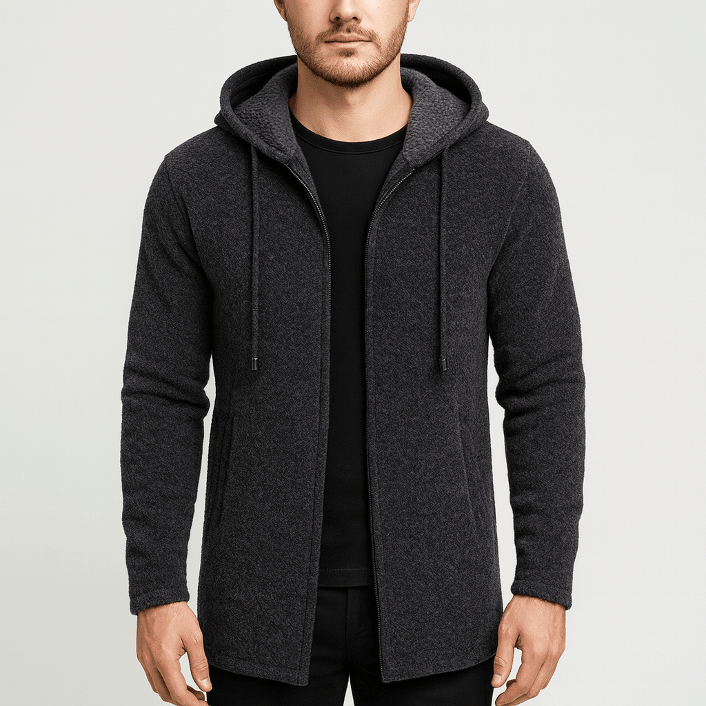 Man wearing a dark gray hooded jacket on a light gray background