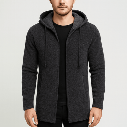 Man wearing a dark gray hooded jacket on a light gray background