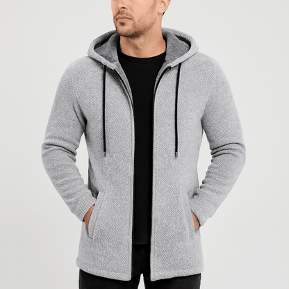 Man wearing a gray hooded jacket on a light gray background