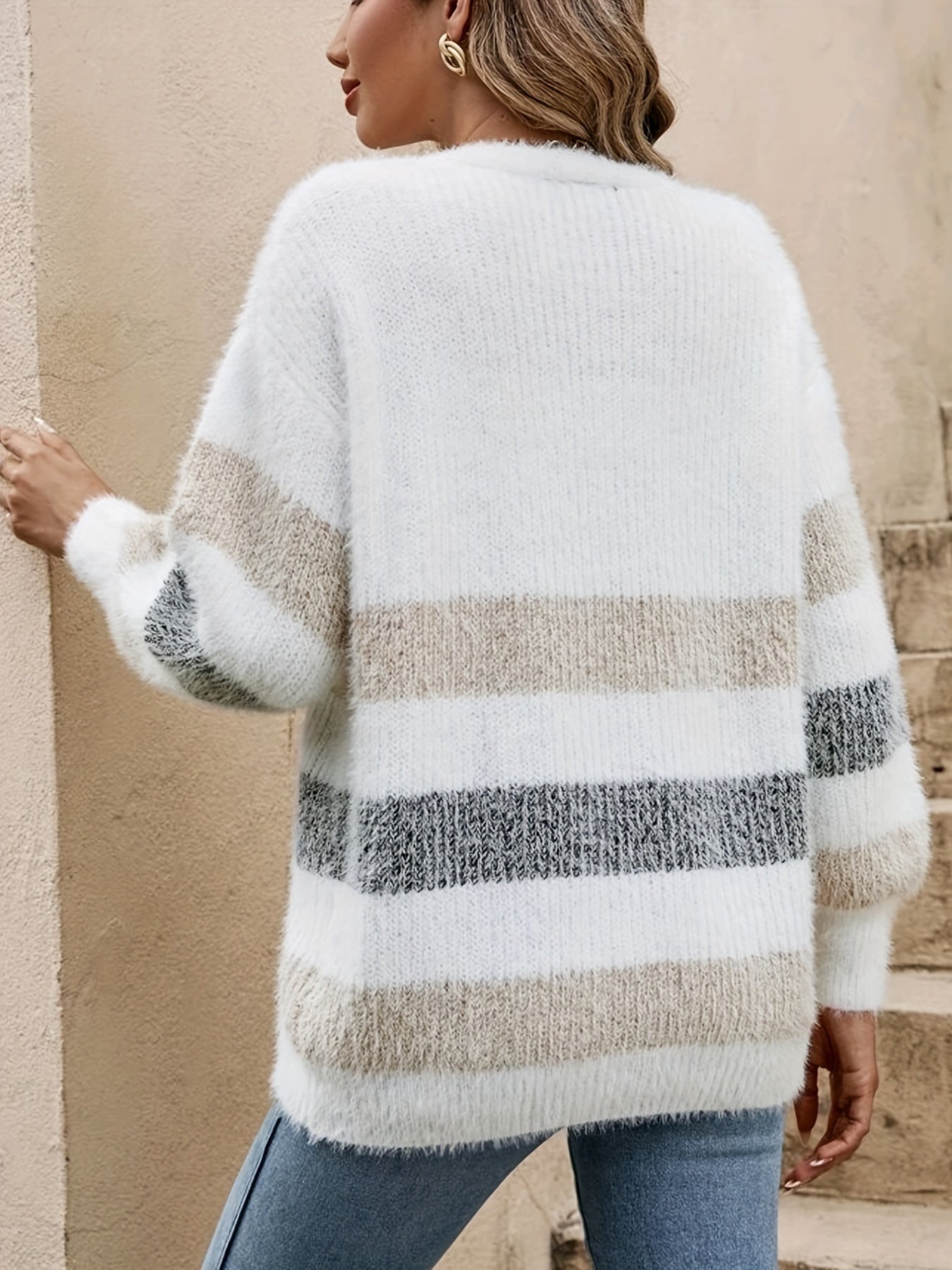 Person wearing a striped sweater with a neutral background