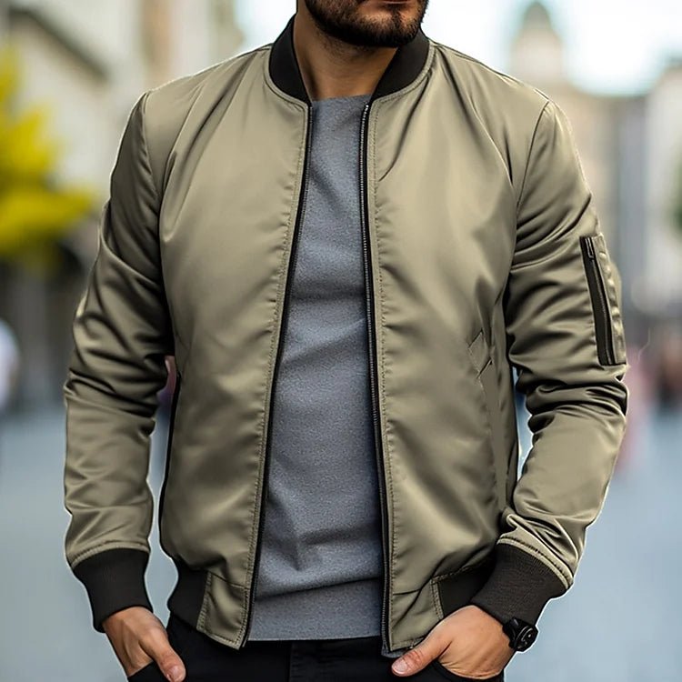 Man wearing a green bomber jacket with a blurred background