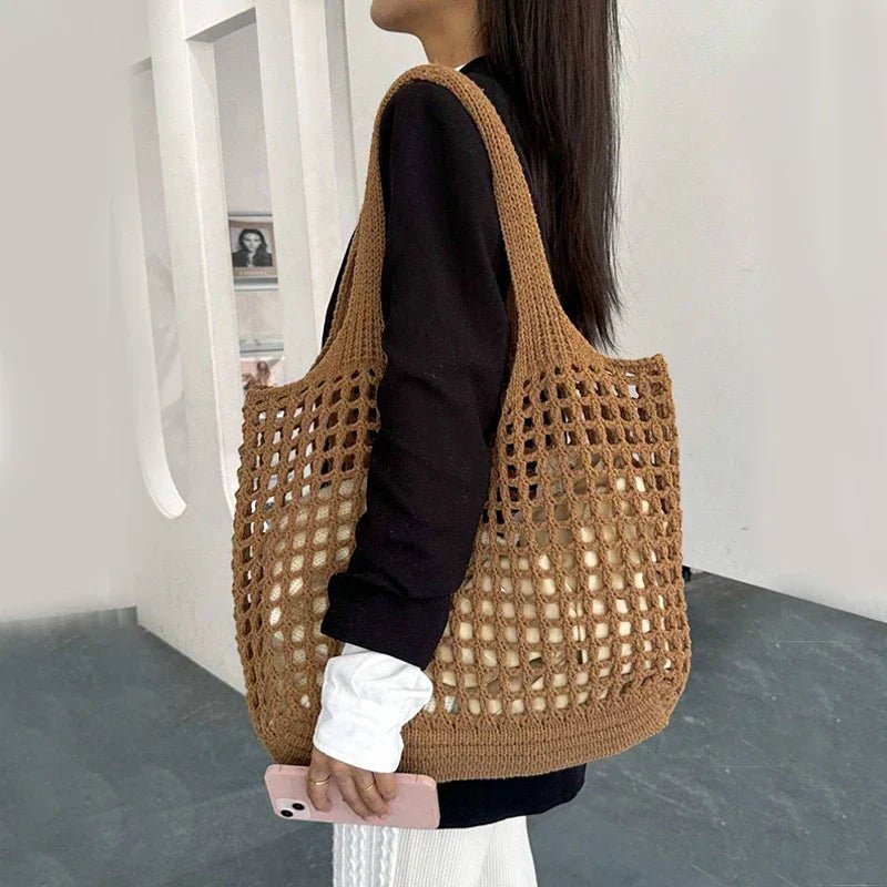 Person holding a brown woven bag in an indoor setting