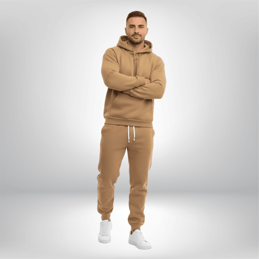 Man wearing a beige tracksuit with white sneakers on a light gray background