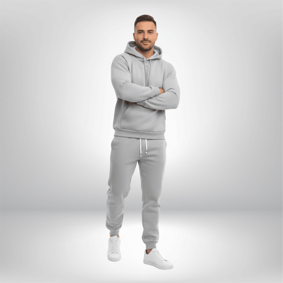 Man wearing a gray tracksuit on a light gray background