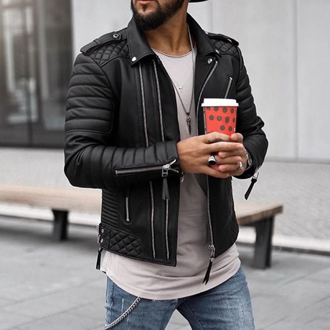 Man wearing a black leather jacket holding a red cup with a polka dot pattern.