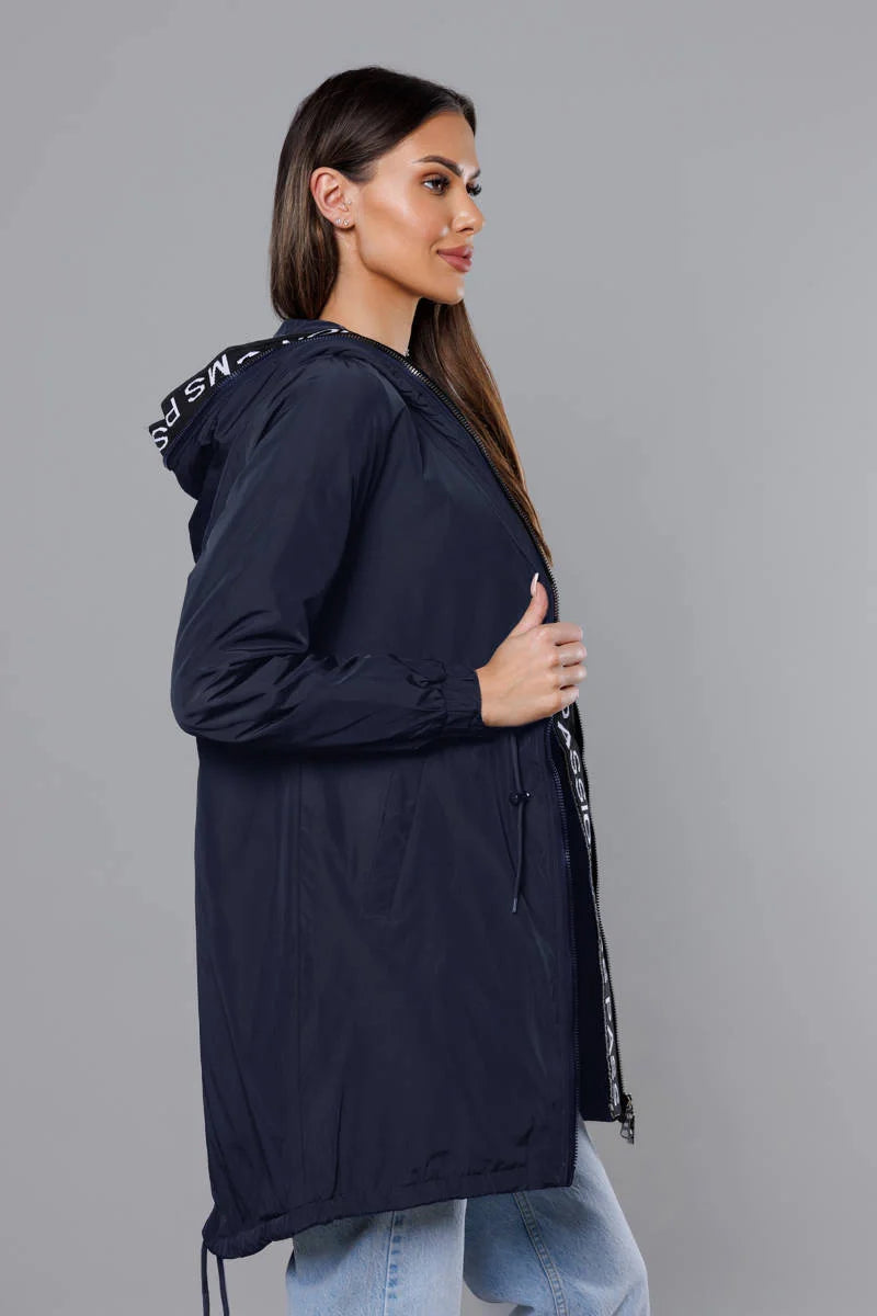 Woman wearing a navy blue hooded jacket with a gray background