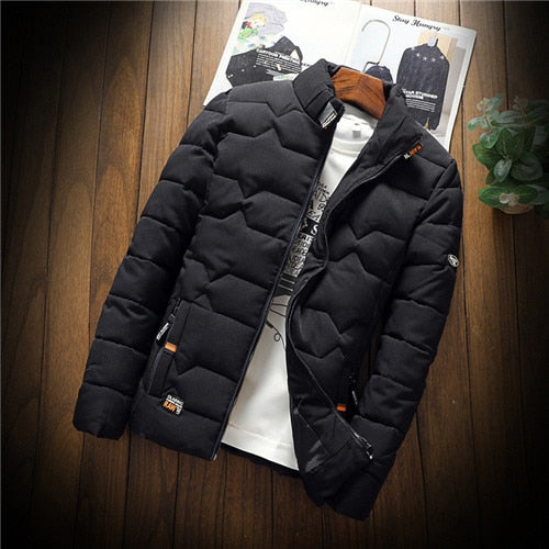 Black puffer jacket on a wooden surface with a magazine in the background