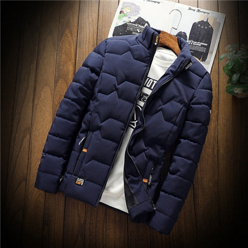Navy blue puffer jacket on a wooden surface with a magazine underneath