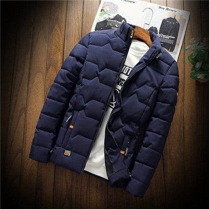 Navy blue puffer jacket on a wooden surface with a magazine underneath